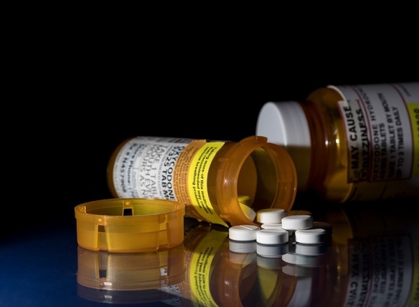 Pills and prescription pill bottles, scattered on a table